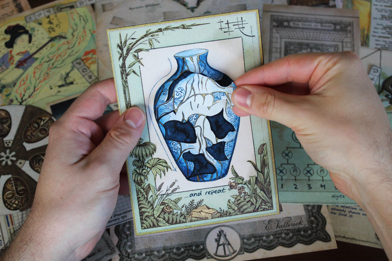 Interactive Japanese kintsugi puzzle from Expedition Around the World printable escape room, showing a player rebuilding a blue and white broken vase by positioning a removable piece. Vintage maps, African mask ciphers, Moroccan mosaic puzzles, ancient temple clues, explorer documents, and travel illustrations surround the challenge. This printable mystery game for adults features hands-on paper manipulation, visual reasoning, decoding, observation, and country-inspired escape room puzzles.