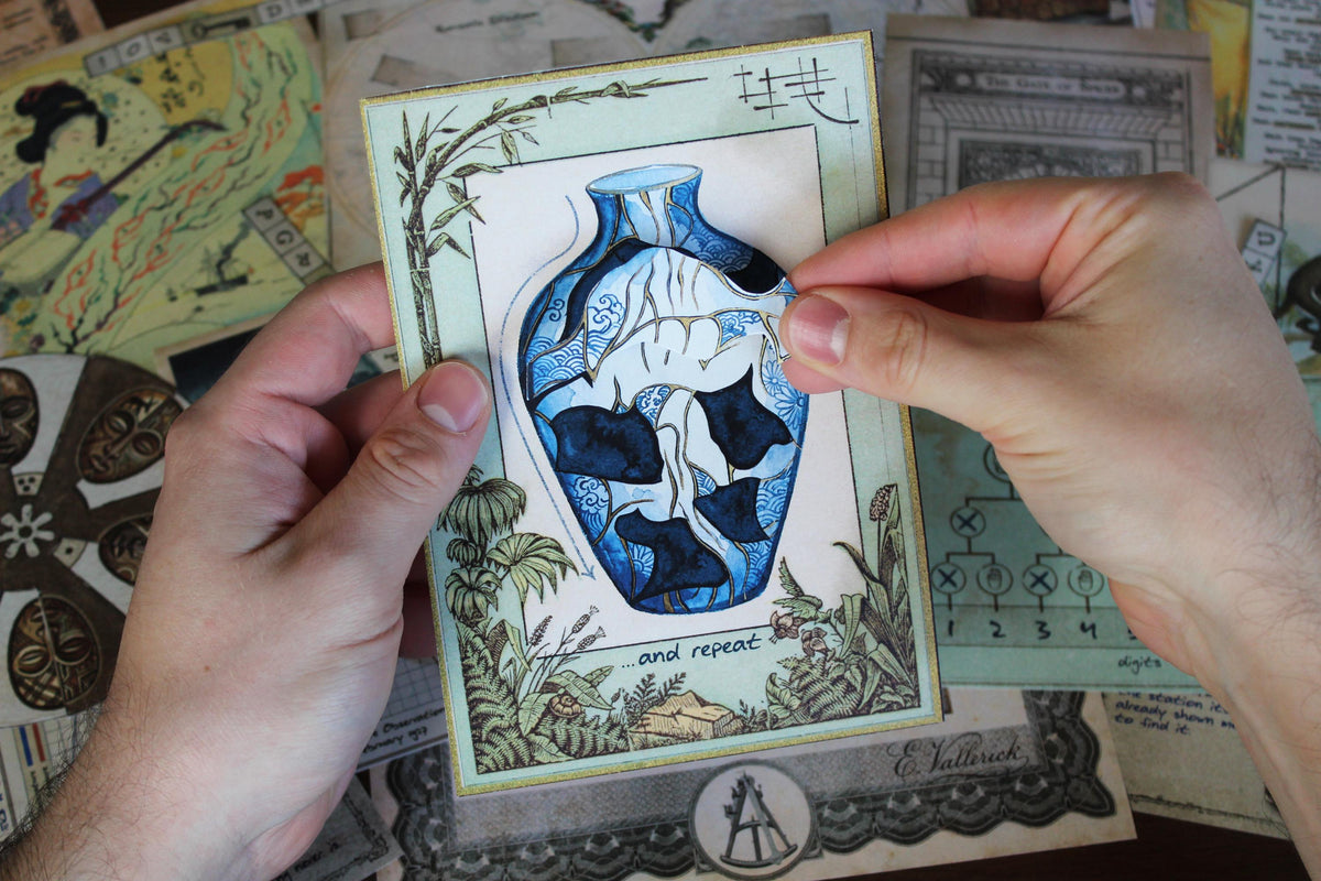 Interactive Japanese kintsugi puzzle from Expedition Around the World printable escape room, showing a player rebuilding a blue and white broken vase by positioning a removable piece. Vintage maps, African mask ciphers, Moroccan mosaic puzzles, ancient temple clues, explorer documents, and travel illustrations surround the challenge. This printable mystery game for adults features hands-on paper manipulation, visual reasoning, decoding, observation, and country-inspired escape room puzzles.