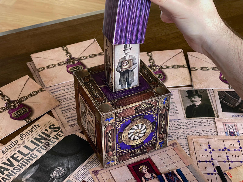 Close-up image of the magic-themed 3D paper cube from The Illusionist's Box printable escape room. Visible around the cube are card puzzles, coded diagrams, secret messages, and vintage newspaper clues. This immersive DIY escape room game from MysteryLocks offers challenging puzzles and creative problem solving for couples, families, and groups looking for a unique escape room experience at home.