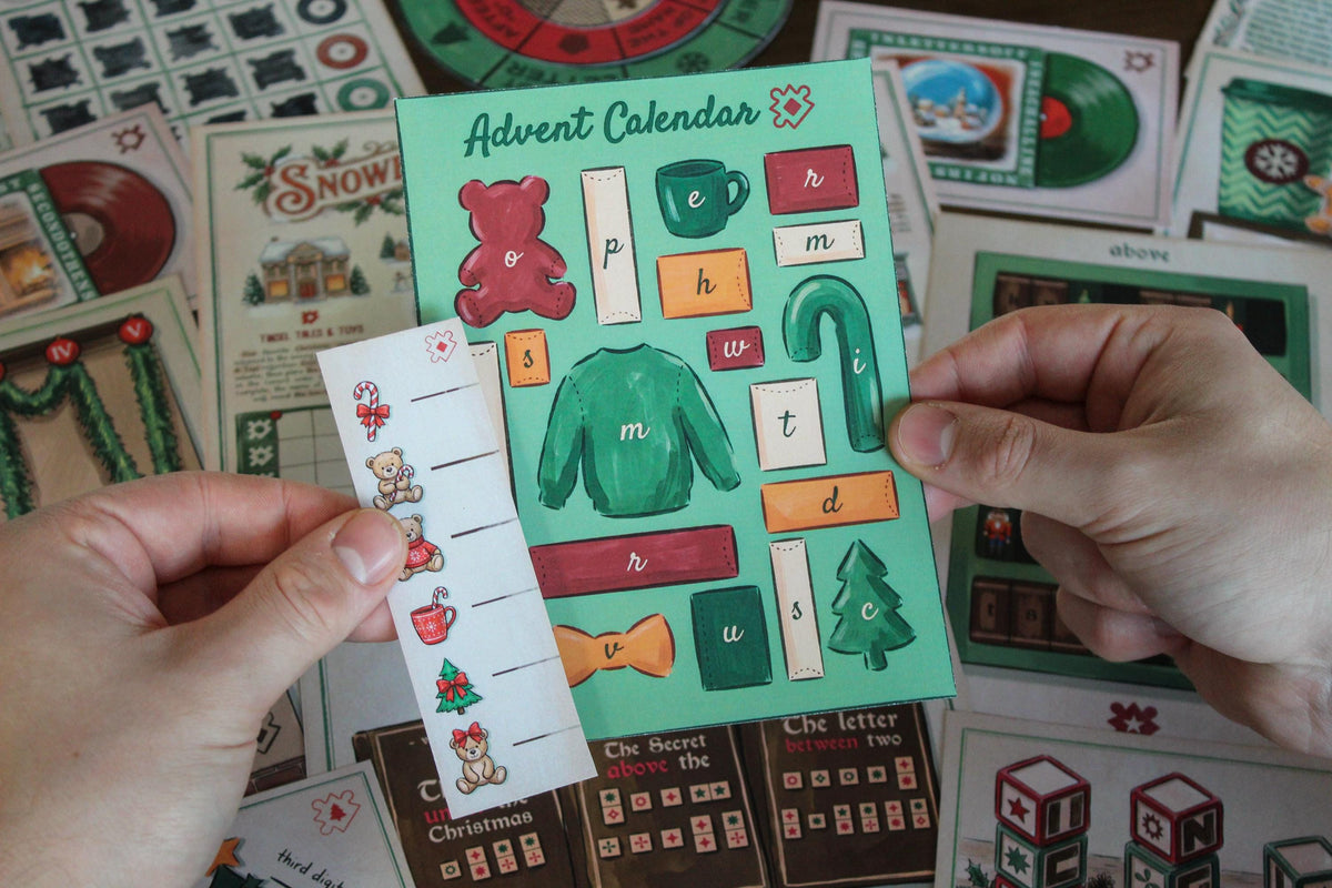 Close-up of hands holding Cozy Christmas printable escape room pieces from the Advent Workshop puzzle, including a green Advent Calendar card with illustrated Christmas objects, letters, a sweater, candy cane, teddy bear, bow, mug, and tree, plus a matching measuring strip. In the background are festive Snowberry Lane materials, decoder wheels, records, book puzzles, map pieces, and other components from the MysteryLocks Cozy Christmas Escape Room.