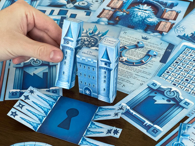 Hand assembling a 3D paper castle from The Snow Queen printable escape room by MysteryLocks. The icy blue towers, labeled “Crystal Tower” and “The Gatehouse,” form part of the winter-themed DIY escape room kit filled with puzzles, runes, and secret clues. Designed for families, teachers, and puzzle lovers, this printable game transforms any room into a frozen adventure full of logic challenges, storytelling, and creative hands-on escape room fun.